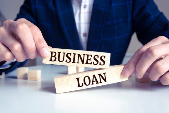 Nigerian small-business owner organising loan documents beside a phone and calculator